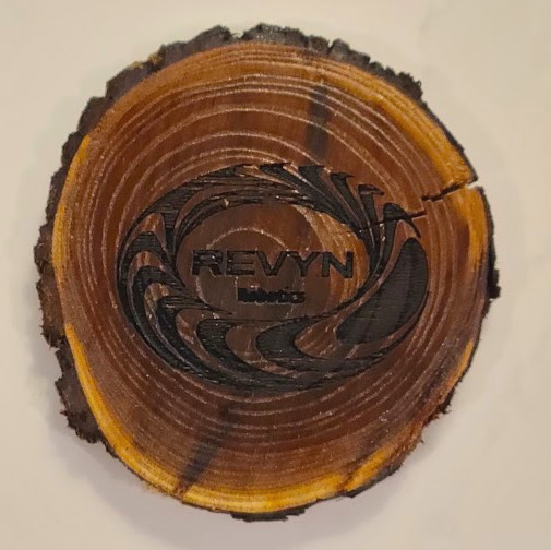 Revyn Logo burned in a wood round